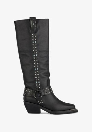 Czarne skórzane kozaki za kolano z ćwiekami, teksturowanym paskiem i chunky obcasem. Posiadają spiczasty czubek i dekoracyjne metalowe detale.