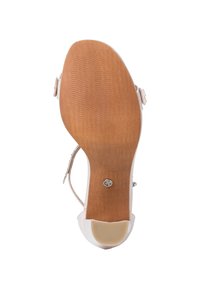 Beige heeled sandal with a smooth, glossy upper, thin ankle strap, and textured wooden sole featuring a circular metal accent.