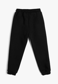 Pantalones de chándal de forro polar negro con cintura y puños elásticos, extendidos sobre un fondo blanco.