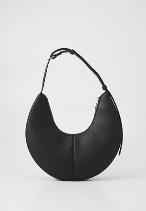 Czarna skórzana torebka na ramię w kształcie półksiężyca z regulowanym paskiem i widocznym szwem wzdłuż środka, ustawiona na jednolitym jasnym tle.