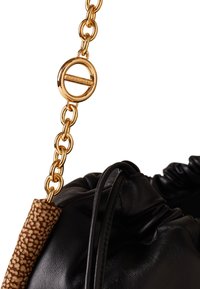 Sac en cuir noir avec un design rembourré, doté d'une bandoulière en chaîne dorée et d'une poignée accent en cuir texturé marron. Détails en métal doré visibles.
