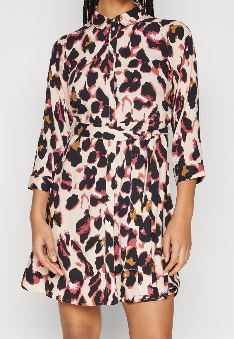 Robe à boutons en tissu léger et à motifs. Présente un imprimé léopard dans des teintes de noir, rose et brun, avec une taille cintrée.