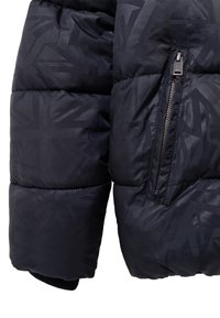 Padded czarna kurtka z subtelnym geometrycznym wzorem, z kieszenią zapinaną na zamek na rękawie oraz prążkowanymi mankietami. Gładka, błyszcząca tekstura.