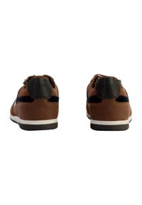 Baskets en cuir marron avec des accents navy, présentant une semelle blanche et un talon noir. Design à lacets, texture douce et style minimaliste.