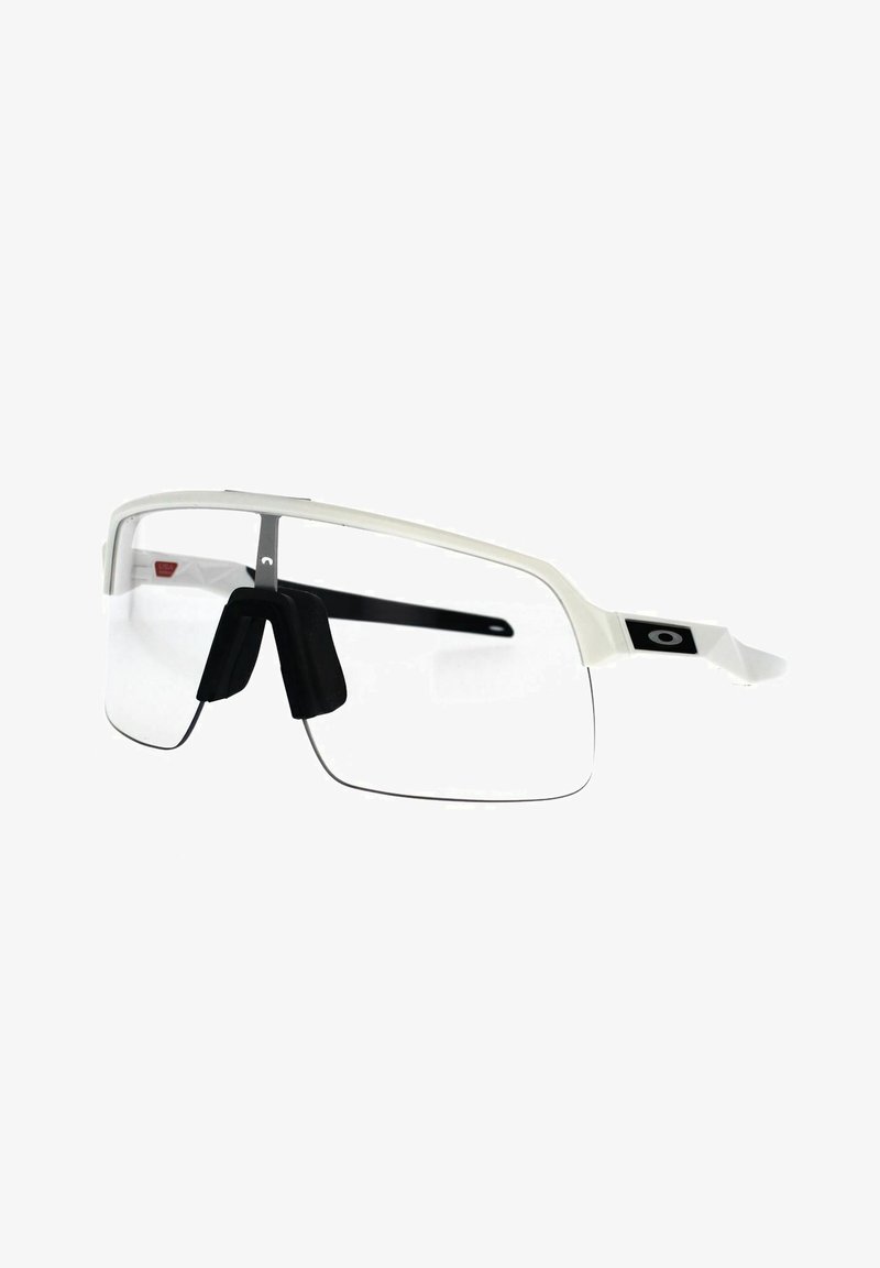 Białe okulary przeciwsłoneczne w półprzezroczystym wykończeniu, z czarnymi noskami i eleganckim podwójnym szkłem. Zawierają detal z logo na zausznikach.