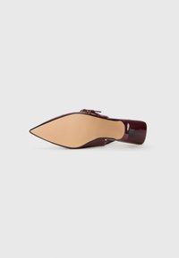 Burgundy patent leather korkeus kengät, joissa on terävä kärki, sileä pinta, kapea korko ja vaaleanbeige kumipohja.