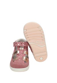 Sandale rose pour tout-petit avec bretelles métalliques, motif de cœurs, fermeture Velcro, et semelle de couleur crème montrant la semelle antidérapante et le nom de la marque "BARTEK".