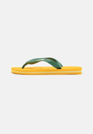 Yellow flip-flop with green rubber straps, textured footbed, and a flat sole. Features a contrasting white accent along the edge.