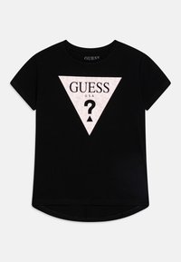Melns t-krekls ar īsām piedurknēm, kam ir rozā trīsstūrveida grafika, kurā centrā ir teksts "GUESS USA" un jautājuma zīme.