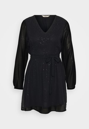 Vestido preto com decote em V, mangas longas transparentes, cintura ajustada e um cinto de laço. Apresenta um tecido texturizado com pontos metálicos espalhados.