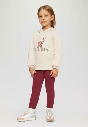 Cremefarbener Hoodie mit einem Hirsch-Graphic, kombiniert mit burgunderfarbenen Leggings. Das Outfit zeichnet sich durch weichen Stoff und eine lockere Passform aus, die für Kinder geeignet ist.