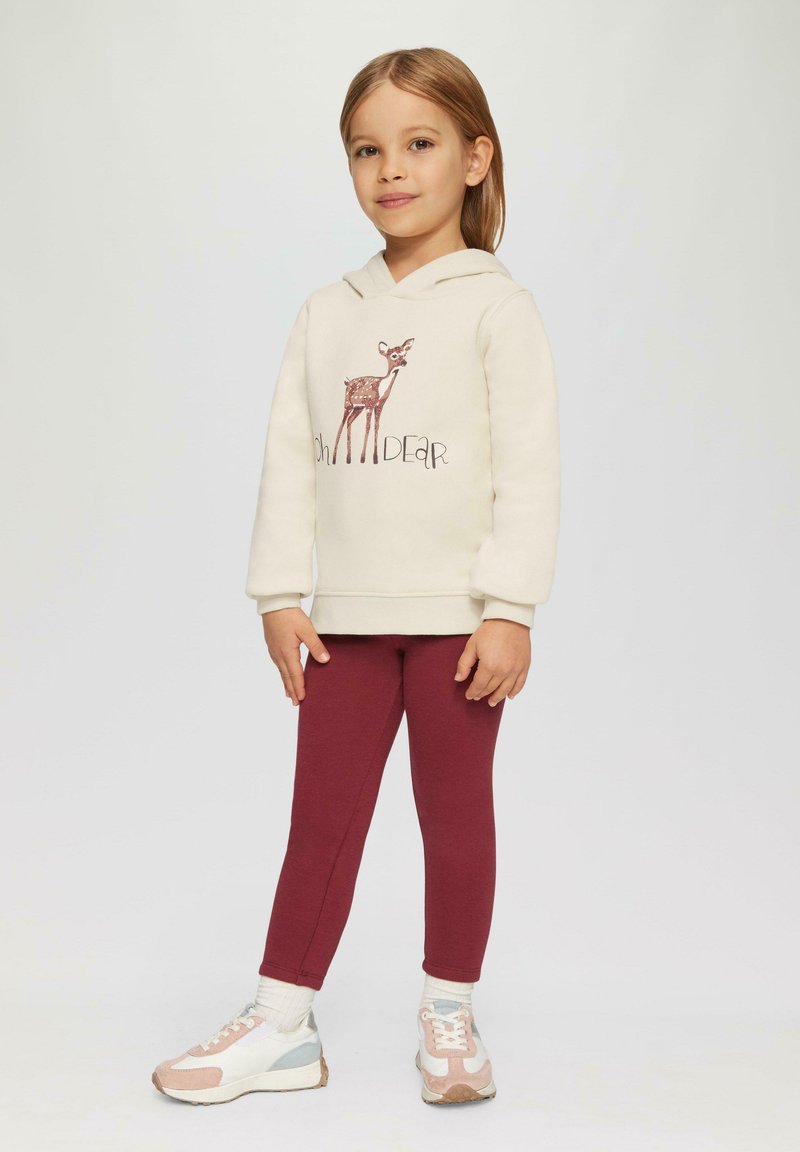 Felpa crema con grafica di un cervo, abbinata a leggings borgogna. L'outfit è realizzato in un tessuto morbido e presenta una vestibilità rilassata, adatta per i bambini.