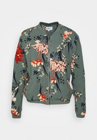Kwiatowa kurtka bomberka w zielonym materiale, ozdobiona czerwonymi i kremowymi kwiatami, z zamkiem z przodu oraz ściągaczami na mankietach i dole.