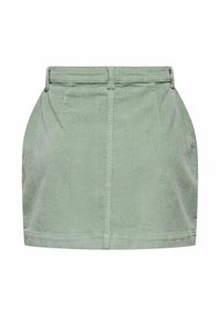 Mini-jupe en velours côtelé vert clair avec passants de ceinture, couture frontale et plis subtils de chaque côté.