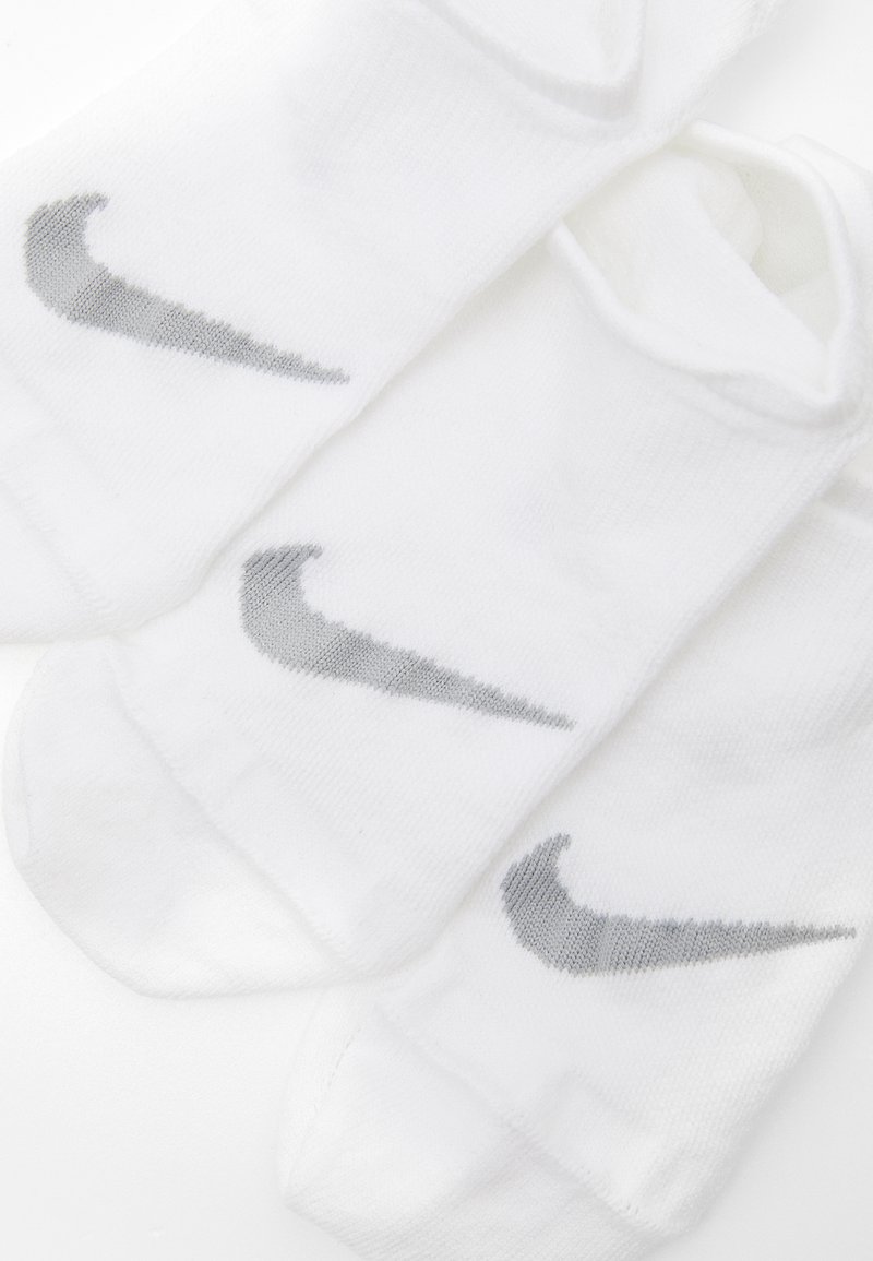 Witte sportieve sokken van katoen, met een lichtgrijze Nike swoosh logo aan de zijkanten. Zachte textuur met ribgebreide boorden en antislip ontwerp.