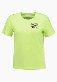 Jasnozielona bawełniana koszulka z krótkim rękawem, okrągłym dekoltem i czarnym napisem "Nigdy na czas" nadrukowanym na wysokości klatki piersiowej. Gładka faktura.