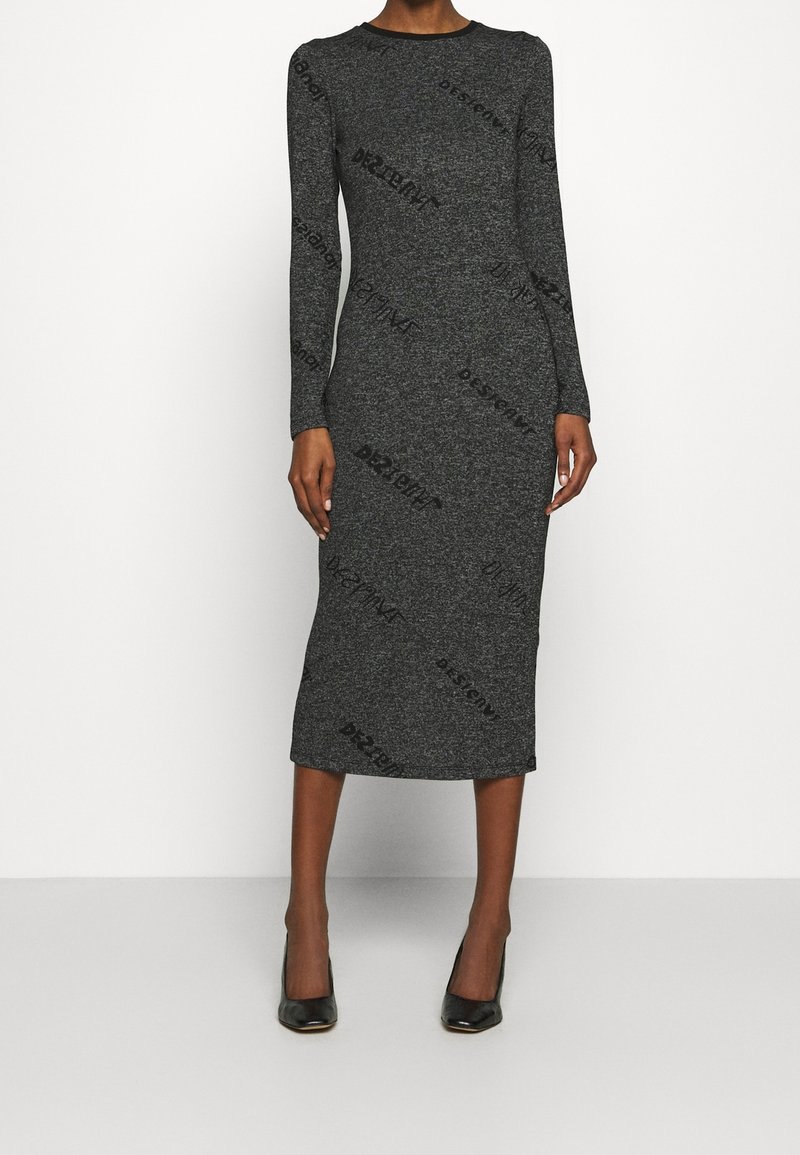 Robe midi gris foncé cintrée à manches longues avec col rond, portée avec des chaussures à talons noires, sur un fond clair uni.