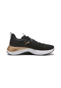 Scarpe da ginnastica nere con un upper testurizzato, dettagli dorati, un battistrada bianco e un design curvo e robusto. Presentano chiusura con lacci e logo.