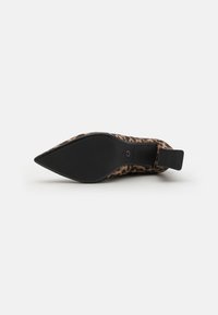 Chaussure à talon aiguille avec un motif léopard. Dessus en tissu doux, semelle en caoutchouc noir et talon rembourré pour le confort.