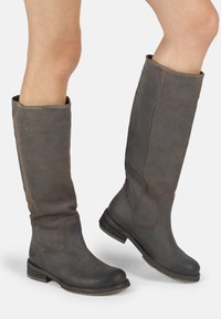 Botas altas de ante gris con un diseño ligeramente holgado, punteras redondeadas y tacones bajos apilados, que muestran detalles de costura visibles.