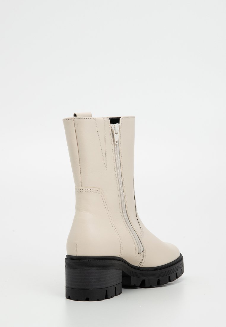 Beige Leder-Ankelboots mit einem seitlichen Reißverschluss, einer kräftigen schwarzen Plateausohle und einer glatten Oberflächenstruktur, die minimale Nähte aufweist.