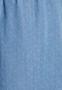Tessuto azzurro chiaro con un sottile motivo a pois bianchi. Il materiale sembra morbido con una trama liscia, caratterizzato da una leggera lucentezza.