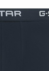 Schwarze Boxer-Shorts mit breitem elastischen Bund, der teilweise weißen Text "G-STAR" in fetten Buchstaben zeigt.