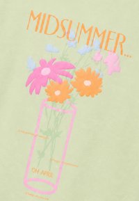 Έγχρωμα λουλούδια σε ροζ βάζο με το κείμενο «MIDSUMMER» από πάνω και φράσεις για νέες αρχές, κοινότητα και να είσαι ο εαυτός σου σε ανοιχτό πράσινο φόντο.