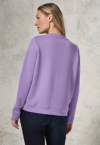 Lila sweatshirt i mjukt tyg med lång ärm och rundad halsringning. Designad med en avslappnad passform och minimala sömnadsdetaljer.