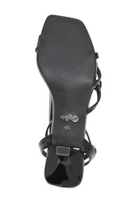 Sandale en cuir verni noir avec un talon fin, un bout ouvert et plusieurs fines lanières. La semelle présente une surface texturée pour une meilleure adhérence.