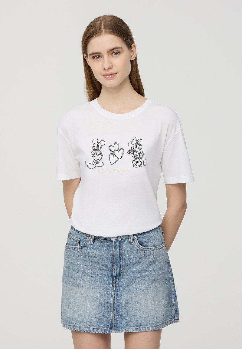 T-shirt bianco in cotone con disegni in linea neri di Topolino e Minnie, un cuore e il testo "Mickey & Minnie" sotto le grafiche.