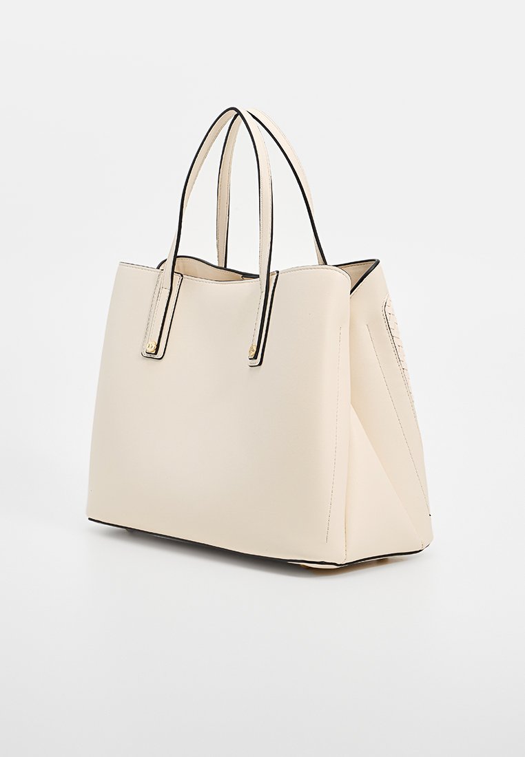 Beige gestructureerde totebag met zwarte afwerking, vlakke bodem, twee rechte handvatten en een zachte textuur. Beschikt over een zijzak met een gestructureerd detail.