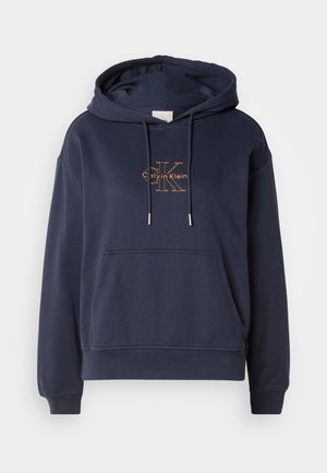 Námornícka modrá bavlnená mikina s predným vreckom, nastaviteľnými šnúrkami a zlatým logom Calvin Klein potlačeným na hrudi.