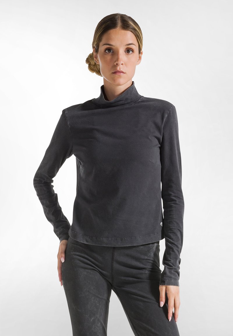 Zwarte longsleeve turtleneck top van zacht, rekbaar materiaal met een slank, aansluitend ontwerp. Beschikt over een subtiele textuurafwerking.