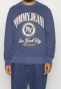 Felpa blu navy in cotone, con scollo rotondo, maniche lunghe e scritte bianche audaci con loghi e dettagli sulla città stampati sul davanti.