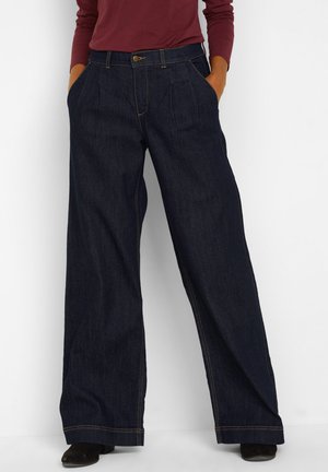 Pantaloni in denim a gamba larga blu scuro con vita alta, caratterizzati da pieghe frontali, tasche inclinate e dettagli di cucitura a contrasto.