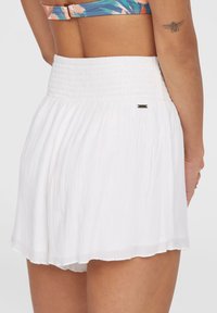 Witte rok met elastische taille en een gestructureerde, vloeiende stof. Beschikt over een subtiele glans en een klein metallic logo-detail nabij de tailleband.