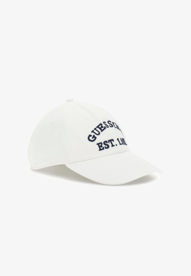 Gorra de béisbol blanca con texto bordado en navy "GUESS" y "EST. 1981" en la parte frontal, con visera curvada y agujeros de ventilación cosidos.