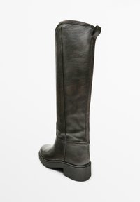 Stivale nero in pelle al ginocchio con texture liscia, punta rotonda e tacco largo, caratterizzato da un dettaglio di cucitura lungo i lati.