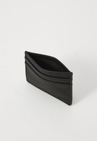 Black leather cardholder featuring multiple card slots, a slim design, and smooth texture, with visible stitching and a minimalist aesthetic.