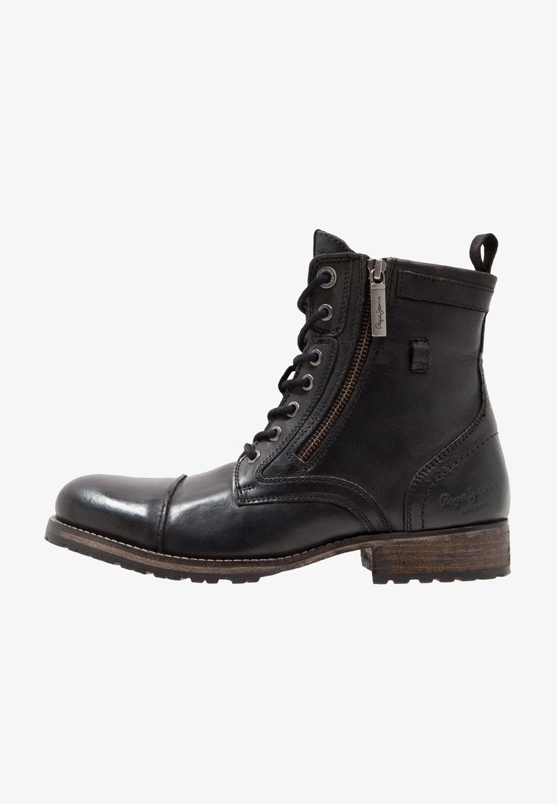 Bottine en cuir noir avec lacets à l'avant, fermeture éclair latérale, talon empilé marron et languette à l'arrière.