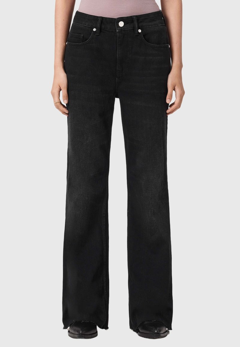 Sorte jeans i vidt snit med fem lommer, knaplukning og rå kant. Fremstillet af blødt, struktureret stof med en let glans.