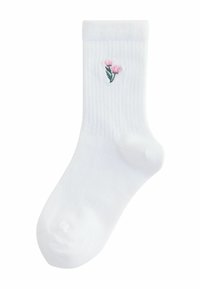 Chaussette en coton blanche avec une texture côtelée, ornée d'un petit motif brodé de fleurs roses et de feuilles vertes sur le côté.