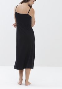 Czarna midi sukienka na cienkich ramiączkach, charakteryzująca się luźnym krojem i miękkim materiałem. Projekt obejmuje prosty dół oraz subtelną, gładką fakturę.