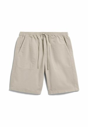 Beige Freizeithosen mit elastischem Bund, verstellbarem Kordelzug und zwei aufgesetzten Fronttaschen, flach auf weißem Hintergrund ausgelegt.