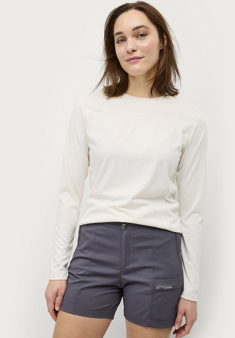 Licht lange mouwen top van witte stof, gecombineerd met donkergrijze shorts met zijzakken en logo detail. Glad textuur, casual pasvorm.