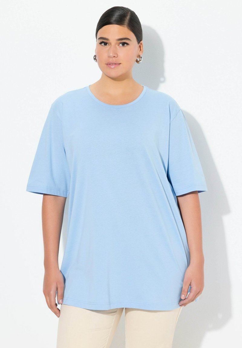 T-shirt oversize azzurro chiaro realizzato in tessuto morbido, con scollo rotondo e maniche corte, dalla texture liscia e semplice.