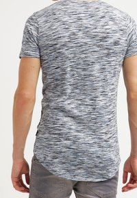 Tričko s krátkým rukávem, šedé a černé pruhované, s mírně zakřiveným lemem, vyrobené z měkké, lehké tkaniny. Obsahuje jemně strukturovaný vzor.