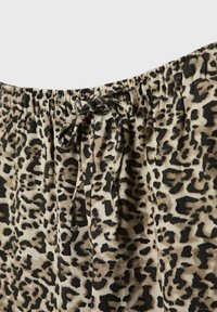 Tissu à imprimé léopard avec une taille élastique froncée et un cordon noué dans des tons de beige, marron et noir.