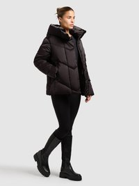 Mustast täidisjope tikandiga teemantmustriga, kõrge krae, ees tõmblukk ja küljetaskud, kombineeritud mustade retuuside ja põlvikute saabastega.